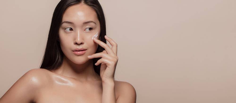 Woman applying a skincare product to her cheek